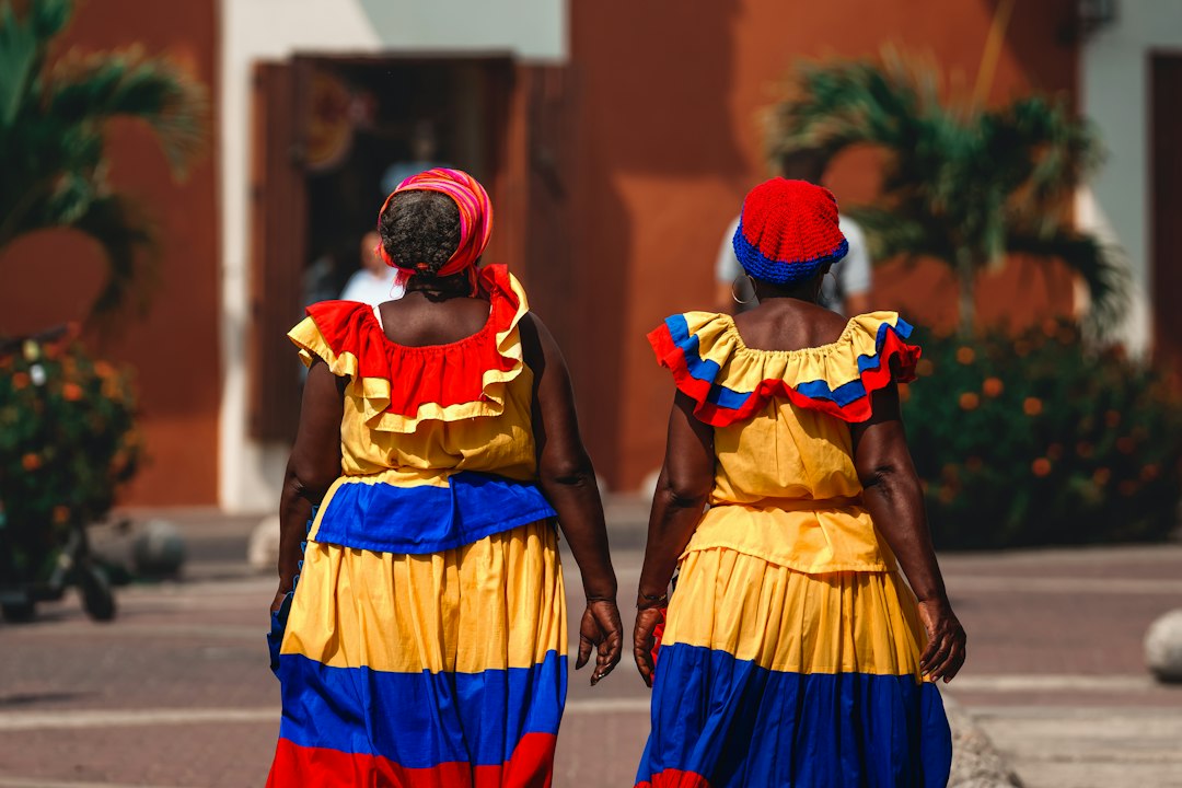 Two women walking down a colorful street in Colombia